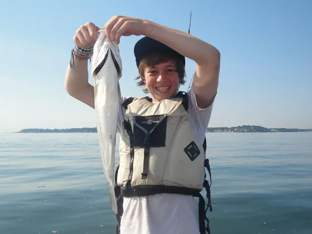 Boy showing off his fishing catch 