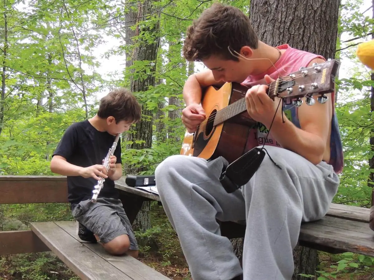 Two boys playing music together at Camp Kabeyun 