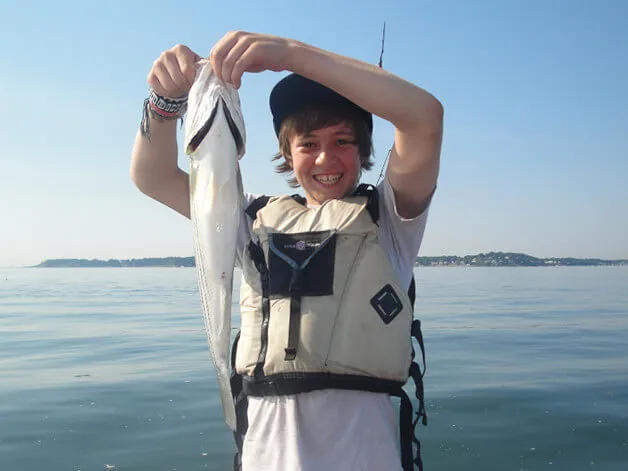 Boy showing off his fishing catch